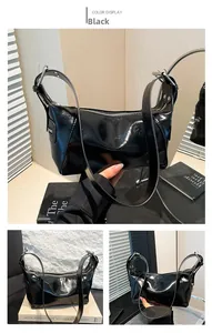 Detalle de bolso de hombro en charol negro brillante con herrajes plateados y correa ajustable