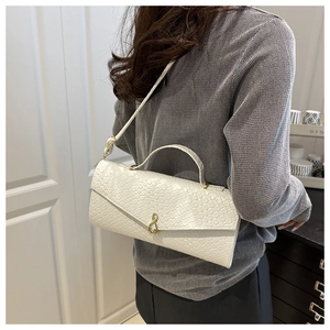 Close-up of woven texture on a white rectangular handbag with a gold twist lock clasp