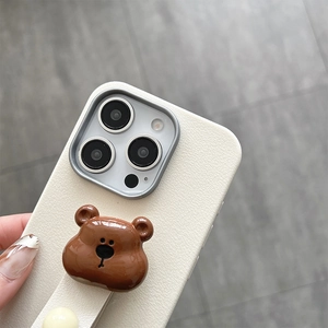 Detailed view of white lychee leather texture and 3D bear stand on a protective phone case