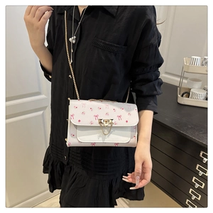 Detail of floral print mini crossbody bag with golden chain and butterfly patterns