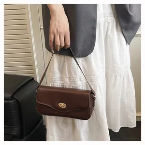 Detail der dunkelbraunen Leder-Baguette-Tasche mit goldenem Drehverschluss-Verschluss