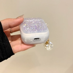 Detail of glitter purple and pearl white AirPods case with shell and pearl pendant