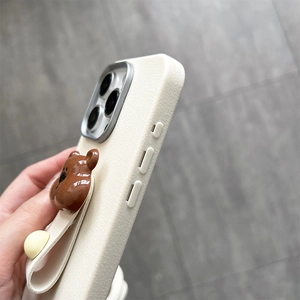 Detail of beige textured leather phone case with 3D bear strap and precise side cutouts