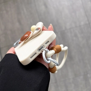 Detail of cream leather phone case with 3D bear decor and thick braided lanyard strap