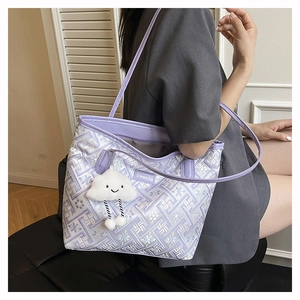 Detail of purple tote bag with geometric patterns and a cute cloud plush keychain charm