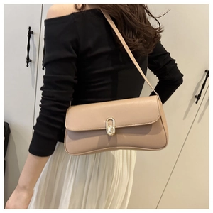 Detail shot of beige leather shoulder bag featuring a stylish oval gold metal twist lock