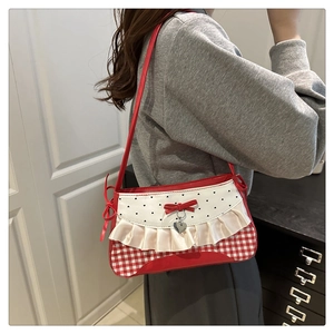 Detail showing the red bow and lace frill of this stylish underarm bag on shoulder