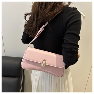 Detail of light pink shoulder bag with a gold oval metal lock and smooth leather texture