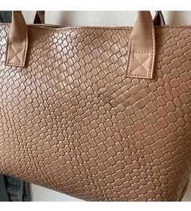 Close-up of brown woven texture leather tote bag highlighting high-quality craftsmanship