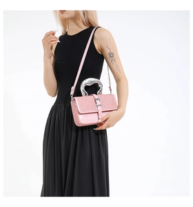 Detail of pink woven leather crossbody bag with silver wave handle and slim strap