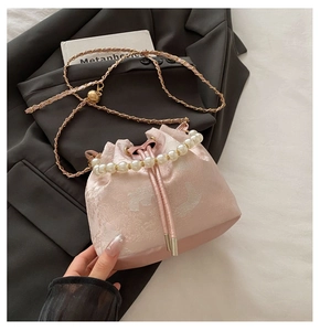 Detail of pink floral jacquard bucket bag with pearl handle and chain strap