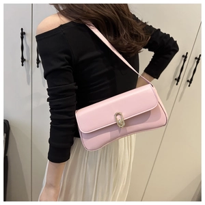 Chic pink matte leather baguette bag worn under the arm with a gold oval metal clasp