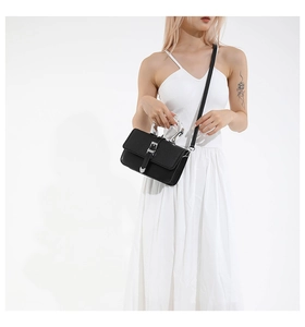 Detail of woven texture handbag with acrylic handle and silver buckle closure