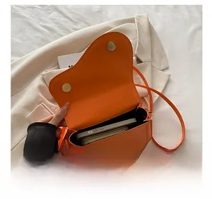 Detail view of the orange saddle bag interior capacity with phone and wallet