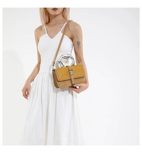 Detail of yellow herringbone weave small flap bag with liquid silver metal handle