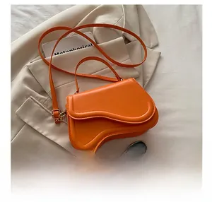 Detail of vibrant orange irregular wave handbag with a smartphone for size reference