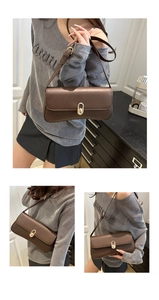 Détail du sac sous le bras en cuir marron foncé avec fermoir doré et bandoulière réglable