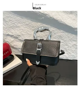 Detail of black leather handbag featuring woven texture and silver curved metal handle