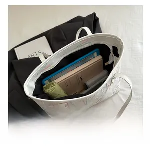 Top view of large white tote bag interior showing capacity for tablets and umbrellas