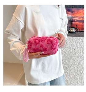Vista detallada del bolso de peluche rosa con motivos de corazones y asa suave