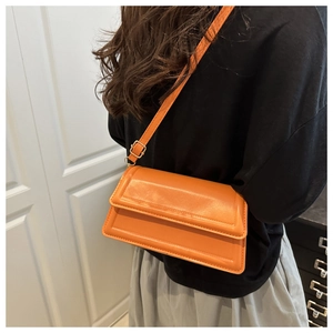 Detailed view of the vibrant orange crossbody square bag with minimalist flap design