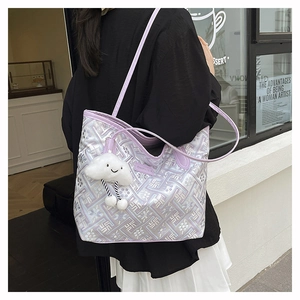 Detail of purple geometric tote bag with silver labyrinth texture and plush charm