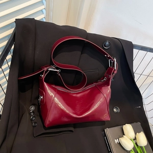 Sac sous le bras rétro bordeaux en cuir verni avec détails argentés sur un blazer