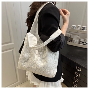 Detail of white daisy lace tote bag featuring exquisite floral embroidery and satin lining