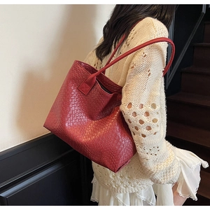 Detail of red woven leather tote bag shoulder strap and premium textured large capacity finish