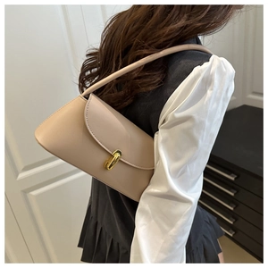 Detailed side view of beige leather shoulder bag with gold oval clasp on the flap