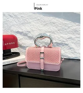 Detailed view of pink crossbody bag with woven texture and carved silver metal handle