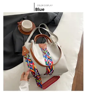 Close-up of beige crossbody bag featuring a colorful geometric ethnic woven shoulder strap
