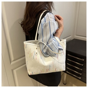 Detail of white tote bag with colorful wave embroidery and textured jacquard pattern