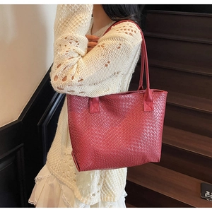 Close-up of a red woven tote bag on a wooden background showing detailed texture