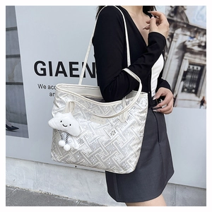 Detail of white glossy tote bag with geometric texture and plush cloud charm accessory