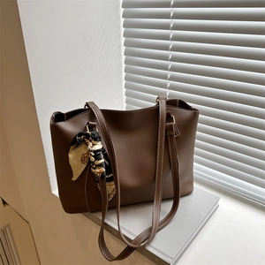 Vintage dark brown leather tote bag with white stitching and floral scarf for summer fashion