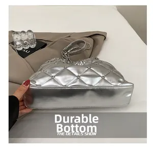 Detail shot of the durable wear-resistant bottom on this silver quilted chain bucket bag