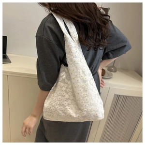 Détail du sac cabas en dentelle blanche avec broderie florale et bandoulière intégrée