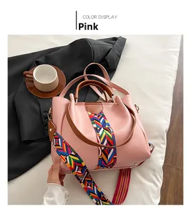 Detailed view of pink tote bag featuring ethnic geometric strap and brown handle