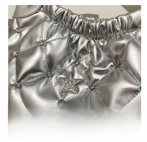 Close-up of silver quilted bucket bag with rhinestone star emblem and metal chain