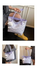 Detail of purple tote bag featuring woven patterns and a plush cloud charm accessory