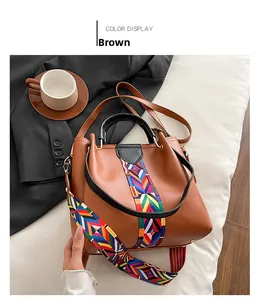 Detail of brown crossbody bag featuring stylish colorful geometric woven shoulder strap
