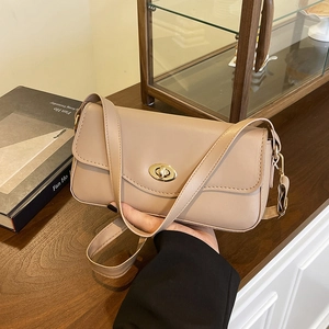 Borsa baguette minimalista in pelle beige con chiusura in metallo dorato in set lifestyle