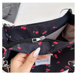 Detail of silver zipper closure on cherry print tote with 'You need this one' label