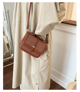 Caramel leather and beige woven crossbody bag worn by a model in a minimalist setting
