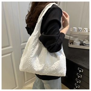 Detail of white canvas tote bag with 3D floral daisy embroidery and shoulder strap texture