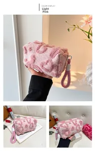 Detalle del neceser de felpa rosa claro con diseño de corazones y asa superior cómoda
