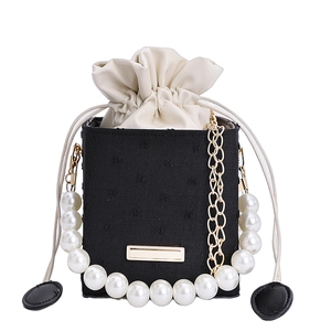 Elegant bucket bag with pearl handle, black embroidered fabric and gold chain strap