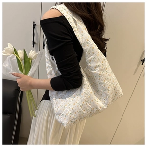 Detailed close-up of white canvas tote bag with delicate floral lace embroidery