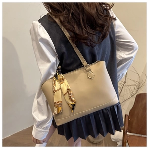 Detail of beige tote bag with vintage chain print silk scarf on the shoulder strap